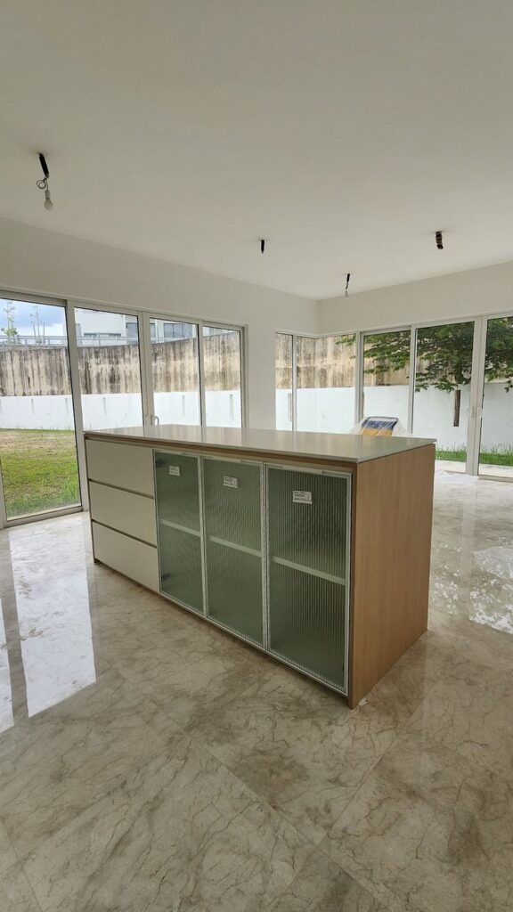 Room with marble floor and a freestanding island unit with frosted/reeded glass cabinet doors and wood end panel. Jade Hills, Kajang, Selangor.