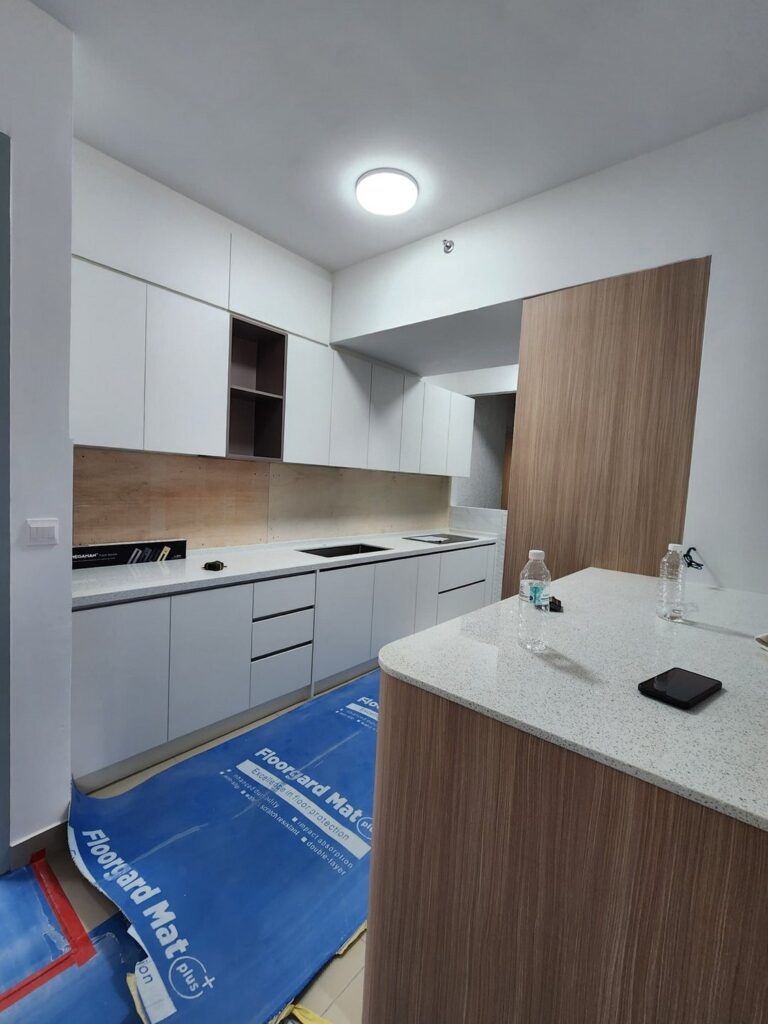 Newly fitted white kitchen with overhead cabinets, open shelving, a wood-veneer panel and a quartz countertop island. M Zenya, Kuala Lumpur.