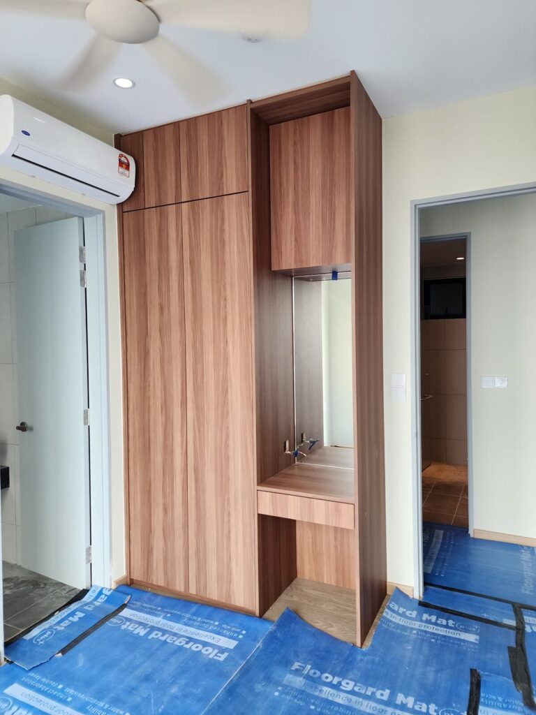 Installed wood-veneer wardrobe and dressing-table unit in a bedroom with a wall-mounted Carrier air conditioner above. Resident Ruby, Sea Park, Petaling Jaya, Selangor.