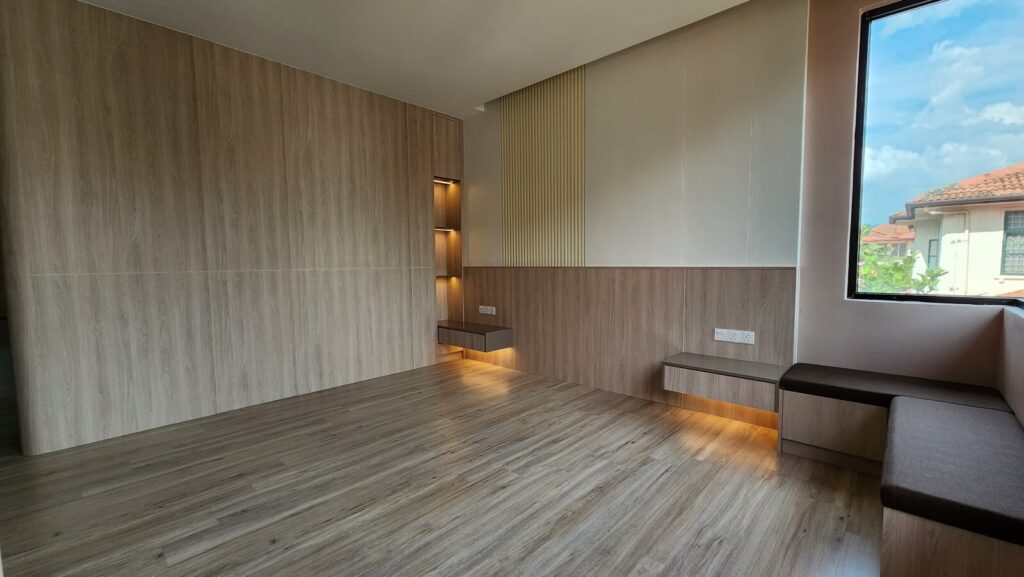 Unfurnished room with wood-grain feature wall, fluted vertical accent panel, built-in floating shelf with concealed lighting and a cushioned bench by a large window. Saujana Akasia, Shah Alam, Selangor.